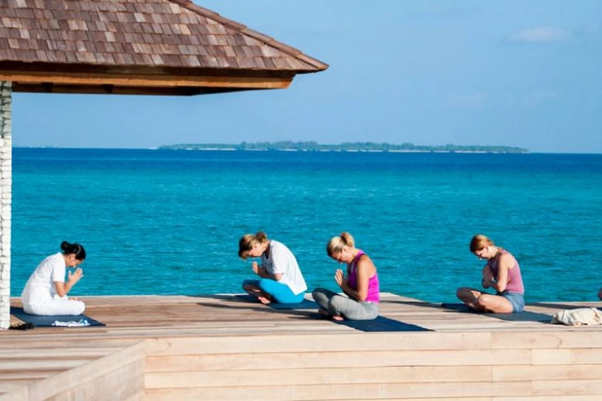 Yoga e massaggi ayurvedici su una spiaggia da sogno di un atollo